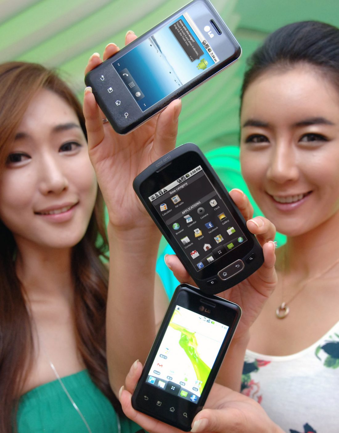 Two models hold up two variants of the LG Optimus Chic and one of the LG Optimus One in a vertical pattern.