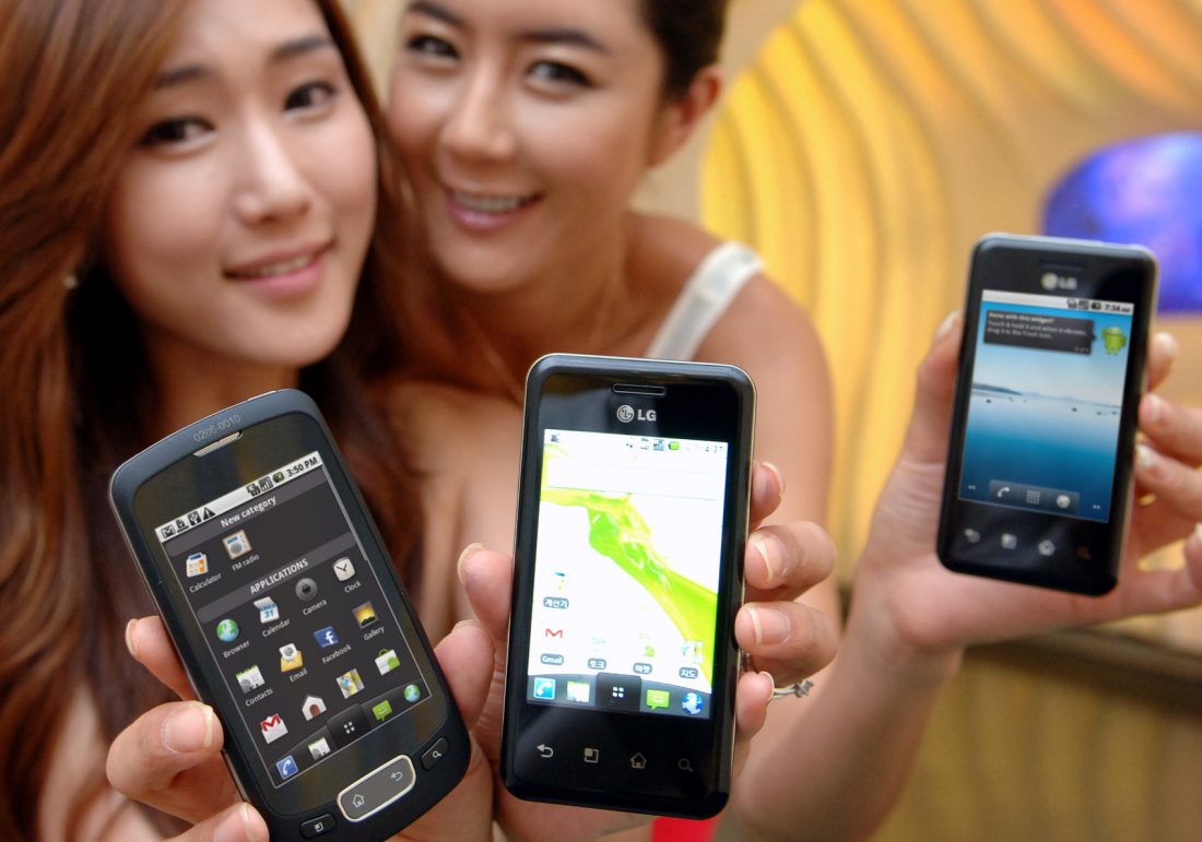 Two models hold up two variants of the LG Optimus Chic and one of the LG Optimus One side-by-side.