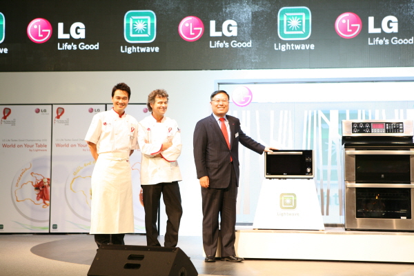 Young-ha Lee, President and CEO of LG Electronics Home Appliance Company, stands at the front of the stage with two participating chefs while showing off LG’s innovative kitchen appliances.