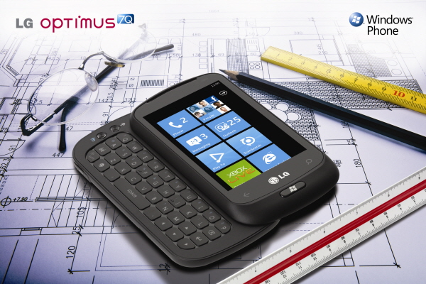 Windows Phone promo shot of The LG Optimus 7Q with slidable keyboard open laid on an architect’s building blueprint, surrounded by rulers, a pencil and a pair of glasses.