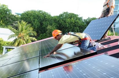 Mohamed Nasheed, president of the Maldives, helps install a solar panel on the president’s official residence, Mulee Aage Palace.