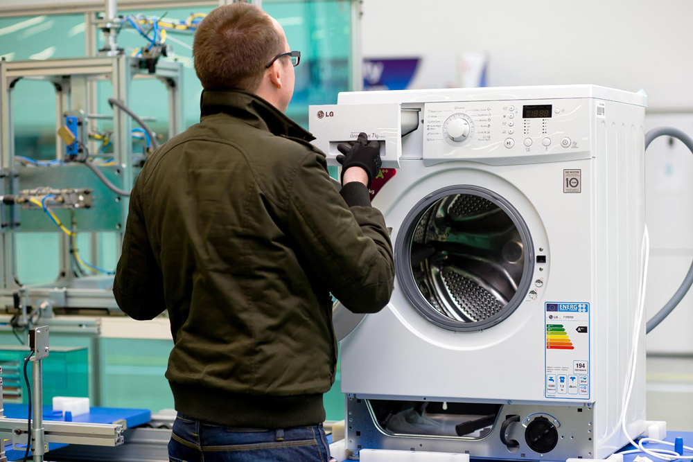 Another image that shows a staff member assembles washing machines on appliance production lines in Poland