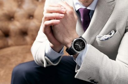 A man in suit holds his hands wearing LG Watch Urban LTE on the left hand.