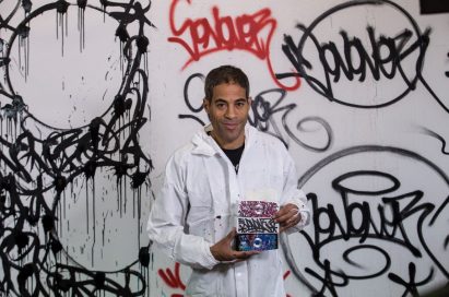 Popular artist JonOne holding up exclusive devices from the LG Portable Speaker art series