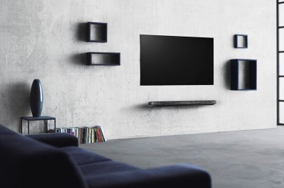 An LG SIGNATURE OLED TV W (model W7) is on the wall of an apartment, it is turned off but blends seamlessly with the art and décor.