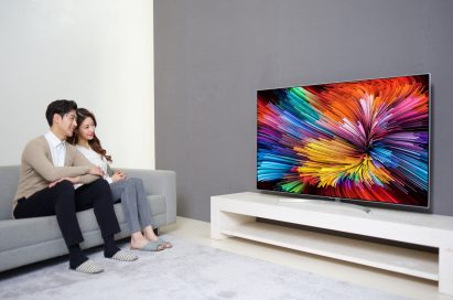 A different shot of a couple sitting on a couch watching the LG SUPER UHD TV (model SJ95)