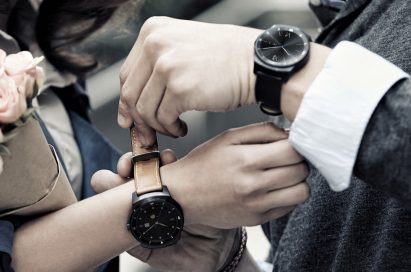 Man wearing an LG G Watch R with black strap helps to put a G Watch R with tan strap on woman’s wrist