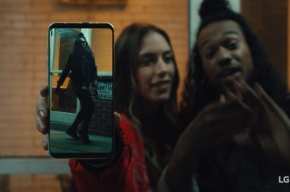 An image from the video clip shows a woman standing next to a man while she holds LG V30 out towards the screen