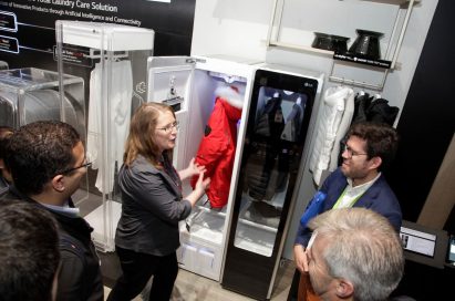 A woman explains LG Styler’s sanitizing capabilities to visitors of LG’s CES 2018 booth.