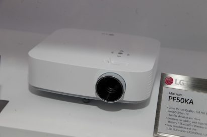Upper front view of LG’s MiniBeam PF50KA projector placed next to its nameplate