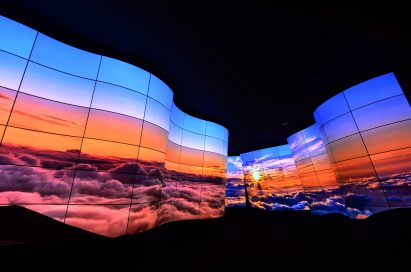 A wide-angled shot of the LG OLED Canyon displaying imagery of a sunrise above the clouds at CES 2018
