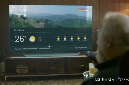 A man using Google Assistant on an LG TV with a remote control to check the weather