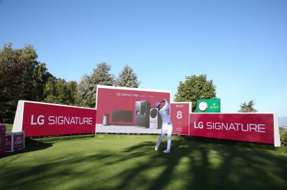 A golfer hits a ball right in front of the LG Signature signage.