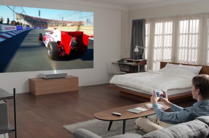 A man playing a video game with the LG CineBeam Laser 4K projector model HU85L